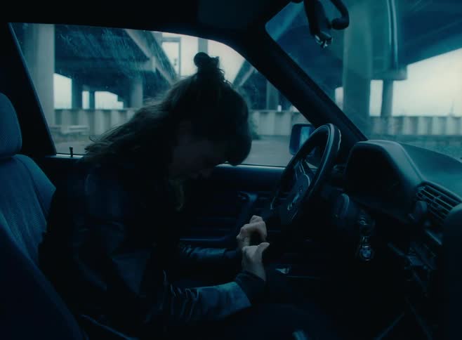 Woman sitting in car starts crying under the bridge