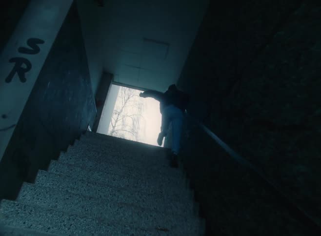 A person running through a tunnel and up a staircase towards the exit