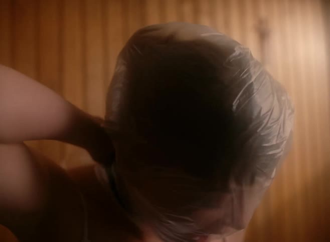 A woman is choking herself with a plastic bag