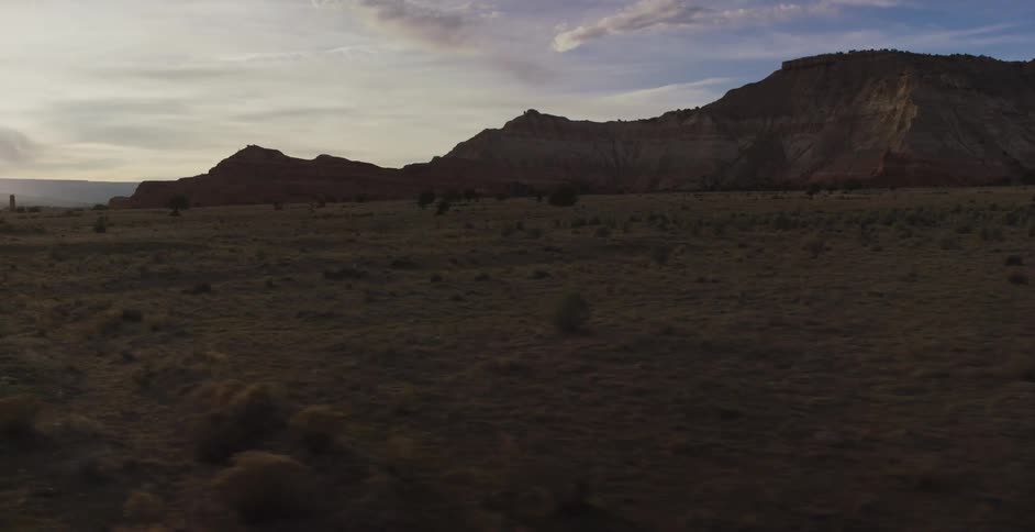 Mountains sit near a wide open grassy plain