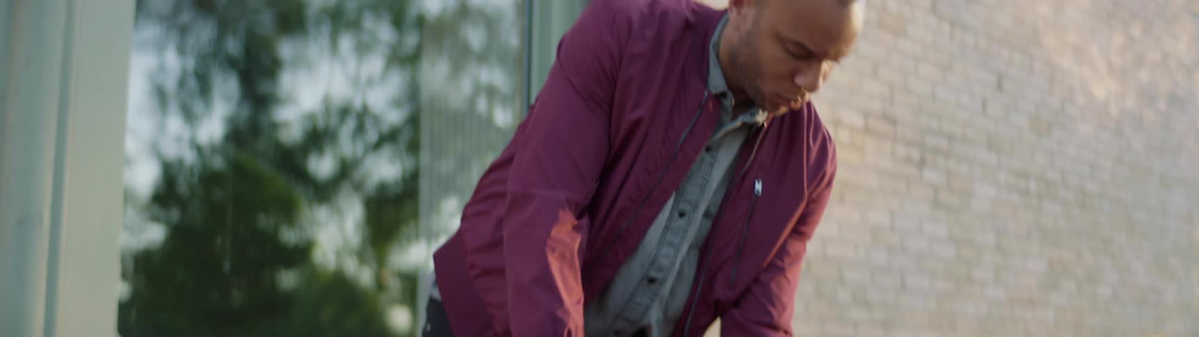 A man sets a chair with guitar case on the street