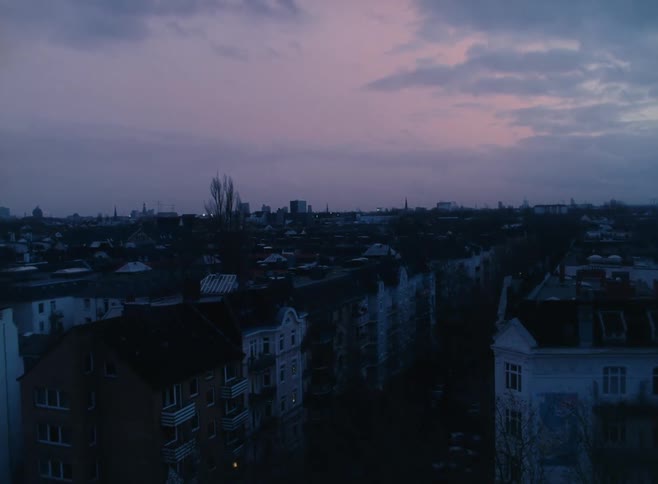 Buildings in a city at sunset from the window of an apartment