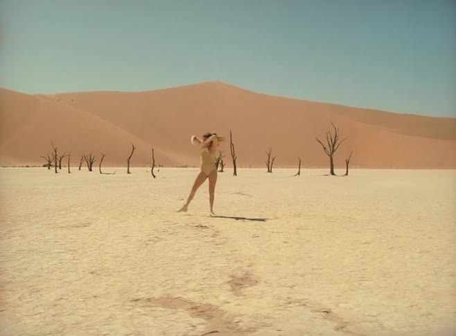 A teen dances in the desert