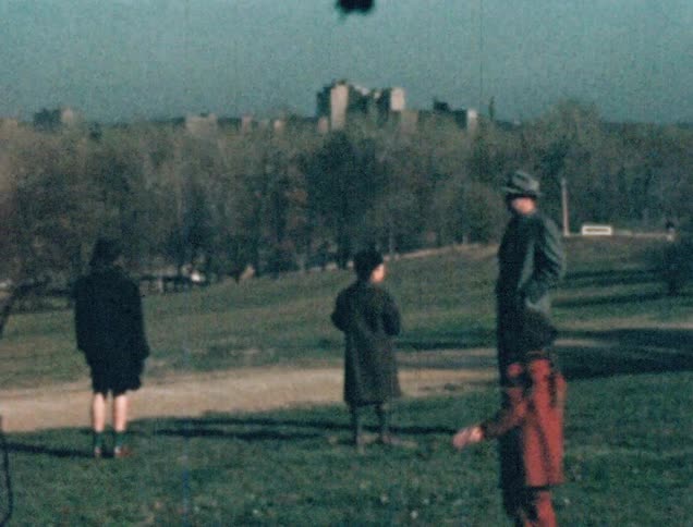 A man with his wife and children points towards the city skyline