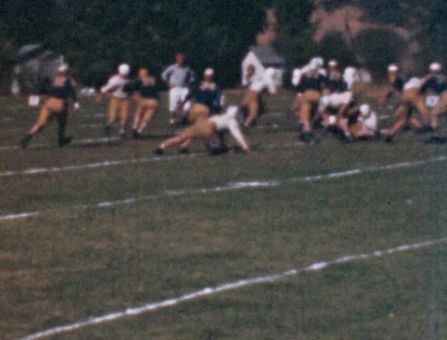 Two football teams run a play on a football field