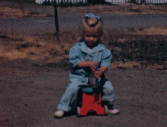 Vintage film of little girl playing with a toy car in the neighborhood