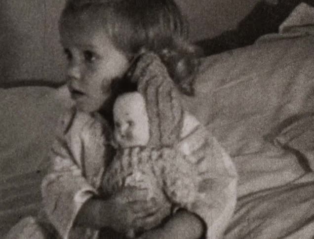 A little girl holding a doll