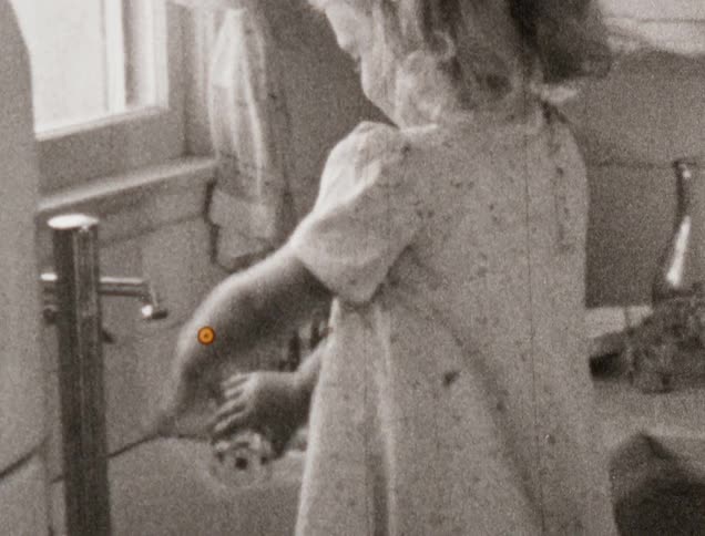 Two little girls wash dishes in their home