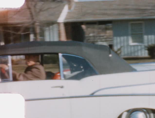 Vintage footage of woman smiling and waving as she drives away in a pink cadillac