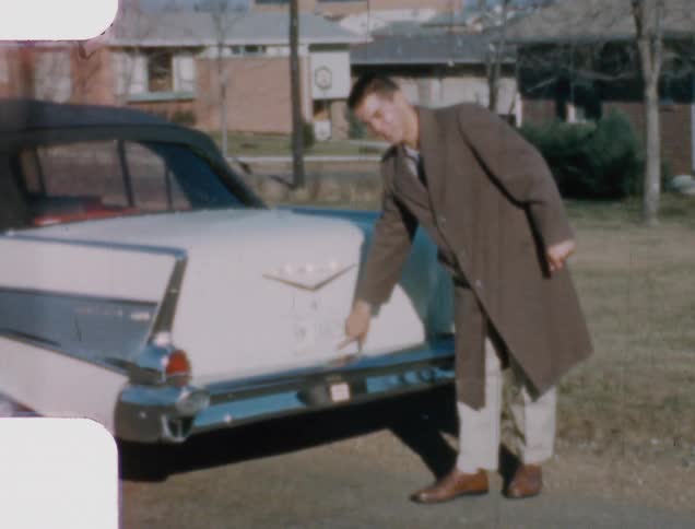 A man closes his trunk and points at it and goes to get in his car