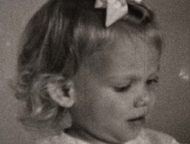A young girl is smiling and looking around