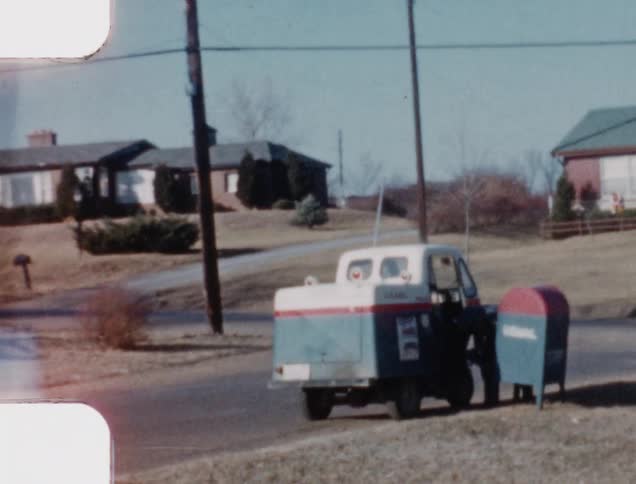 A mailman is picking up mail