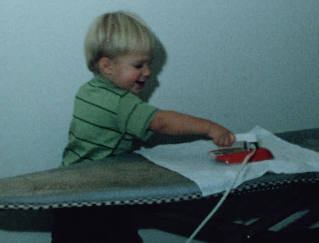 A child is playing with a toy iron