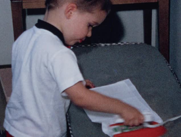 Young boy irons a white cloth with a toy iron