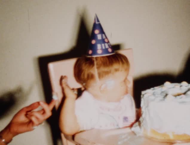 Baby boy refusing frosting from his birthday cake mom is offering