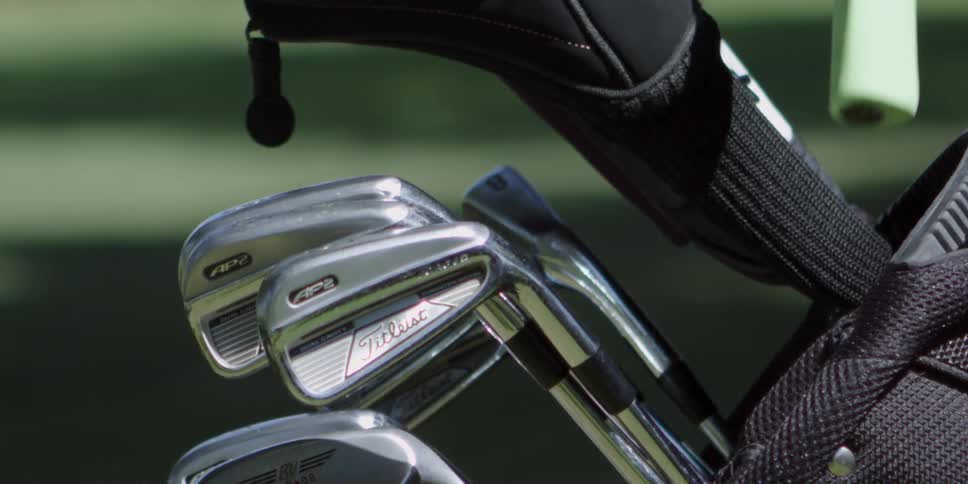 Golf clubs being put in a golf bag