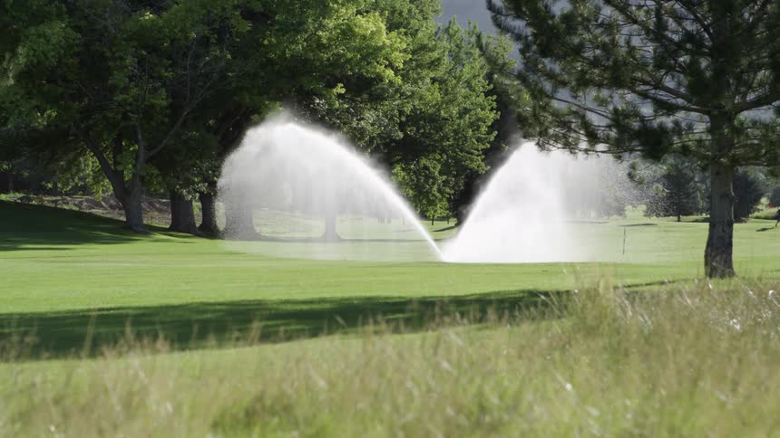 Sprinkler irrigation system watering a golf course