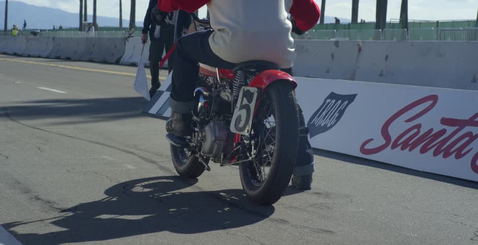 A man on a motorcycle waits for the flag to drop to start a race