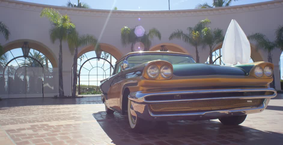 An antique car its in the middle of a building without a roof