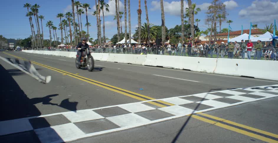 Motorcycle crossing finish line at a racing event at the beach