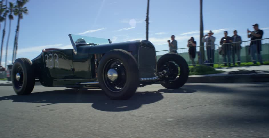 A group of people line the street to watch a drag race