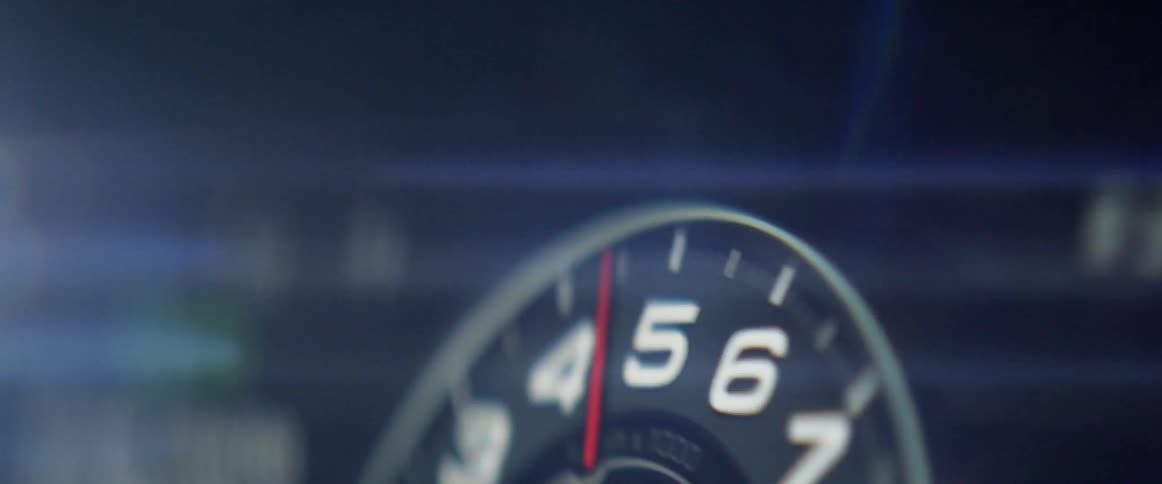 A car dashboard shakes violently as a gauge moves up and down