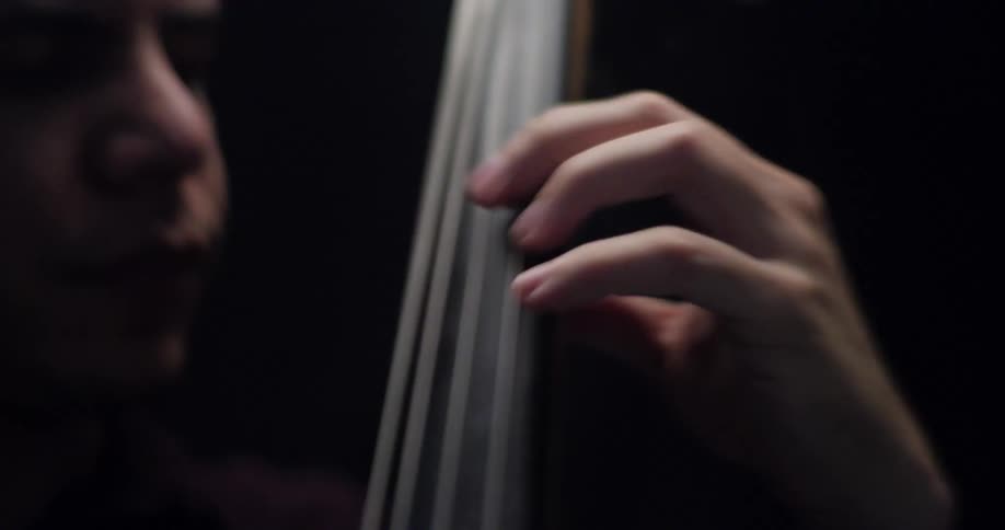 Speed up footage of a man playing an upright bass