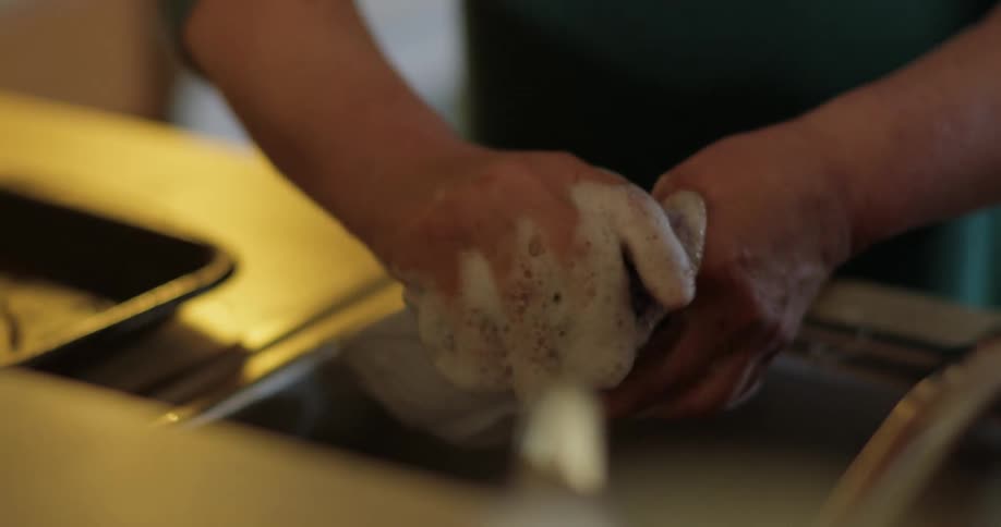 Person washes bowls while another rinses them