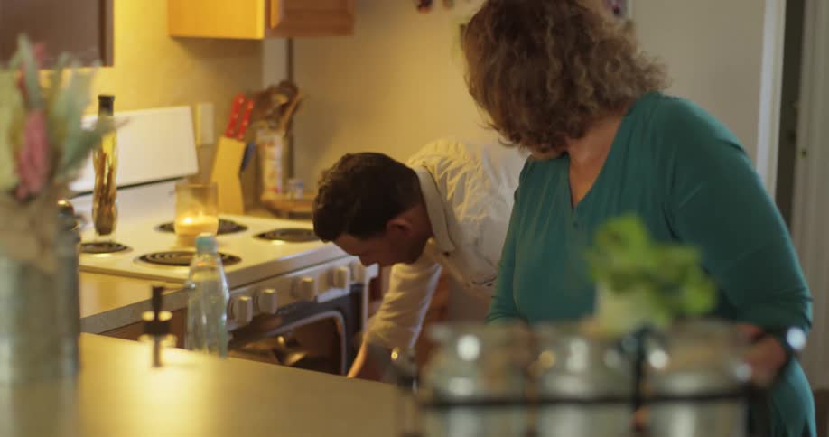 A hispanic woman and hispanic man cook in a kitchen