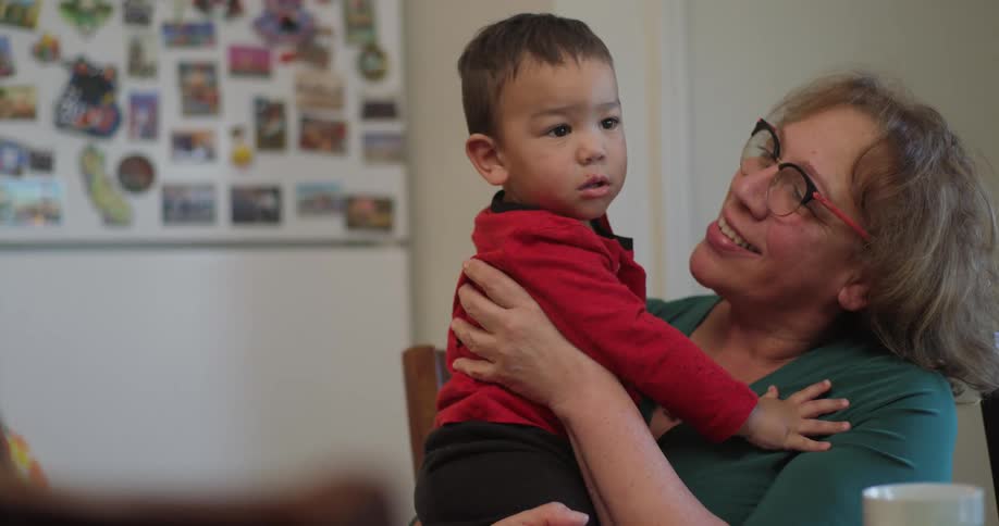 A woman holds a child in her harms smiling
