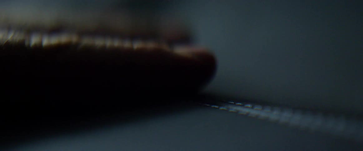 A person runs their fingers across a sewed seam
