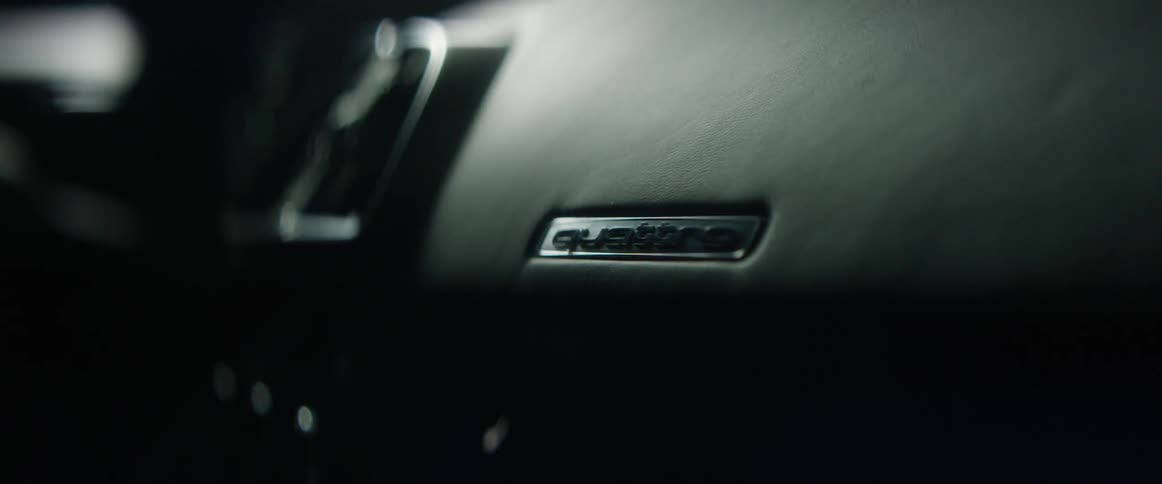 The dashboard of an audi car with light playing over it