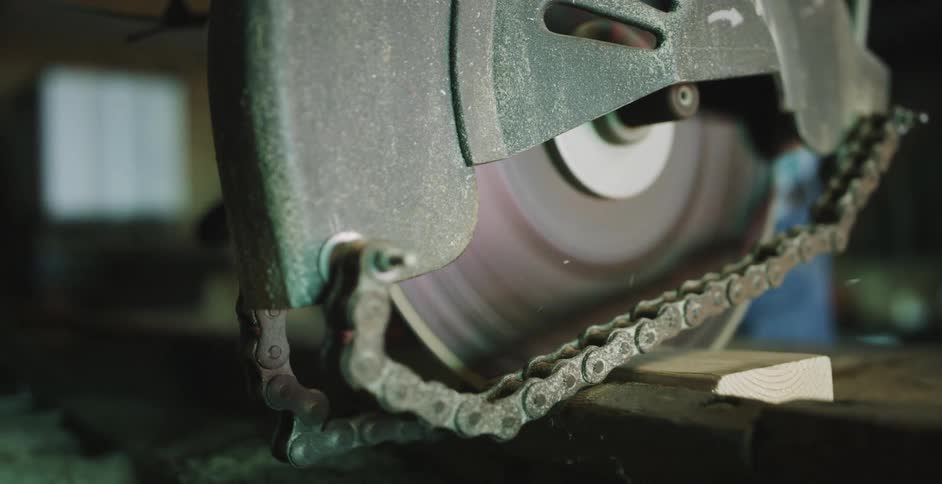 A construction worker uses a circular saw to cut through a piece of wood