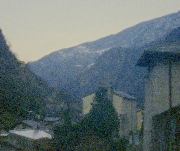 A village with houses in a valley with mountains in the background