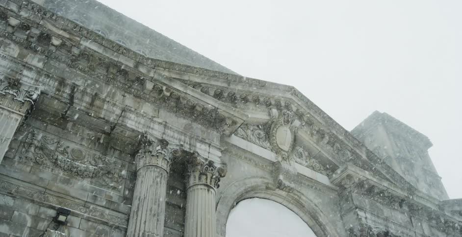 Heavy snow falls on the stone building