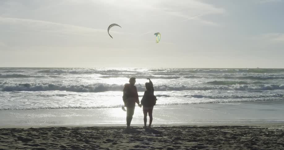 A man and woman are standing by the beach together