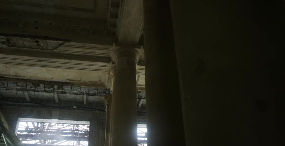 The wind blows snowflakes toward the columns of an underpass or construction site