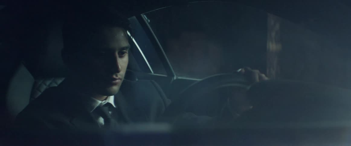 A man sitting in a car and closing the door