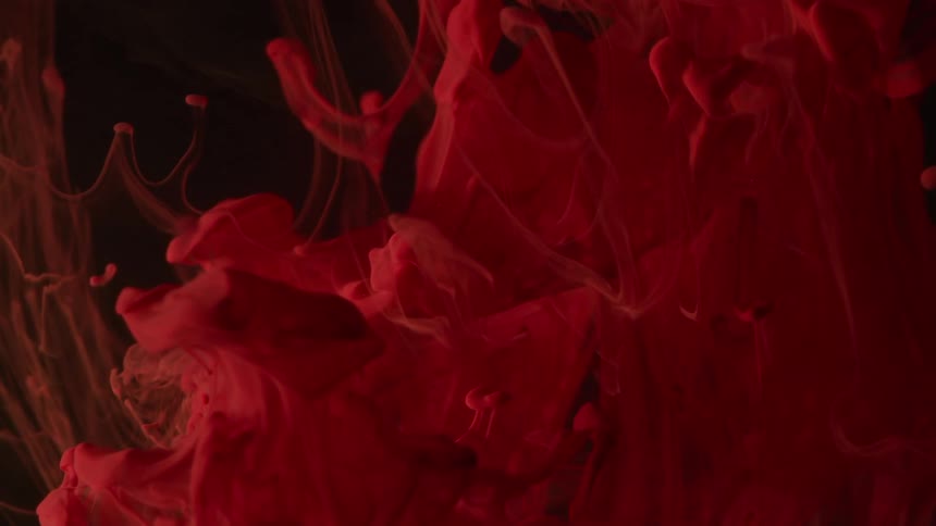 Red vapor like smoke rises in the darkness