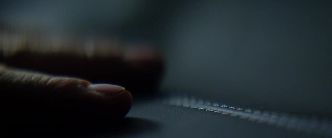 A person runs his fingers over a leather seat