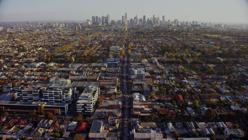 An aerial view of a city and a main road leading toward it