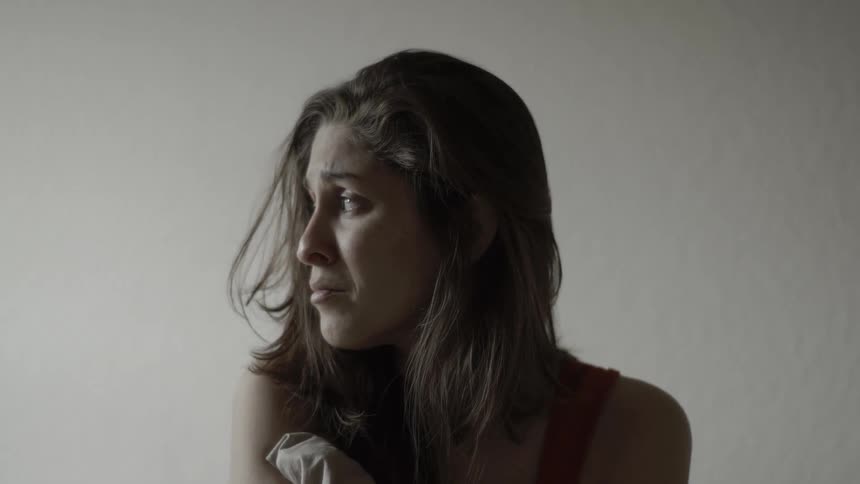 A woman sits and begins to cry