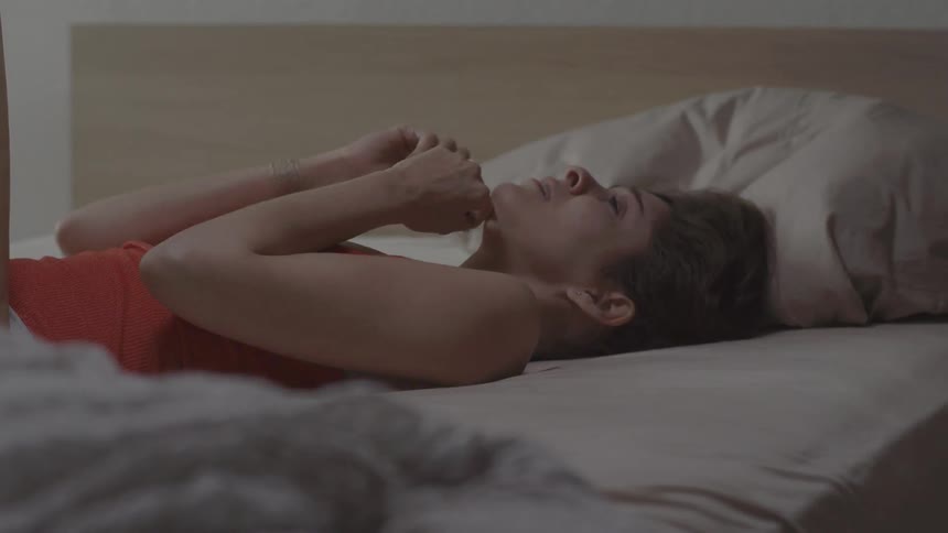 Woman laying in a bed crying