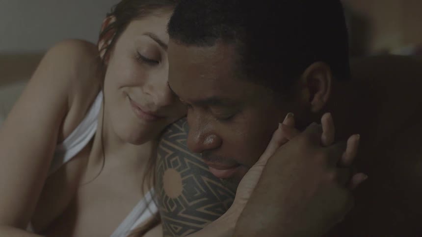 A man and woman cuddle and hold hands