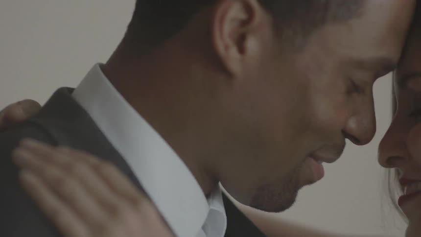 A man is dancing with a woman as they butt heads