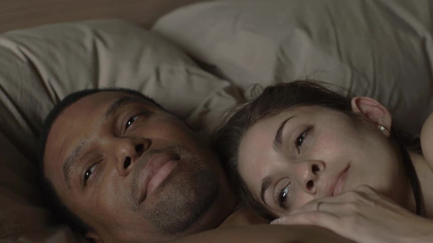 A man and woman laying contentedly in bed