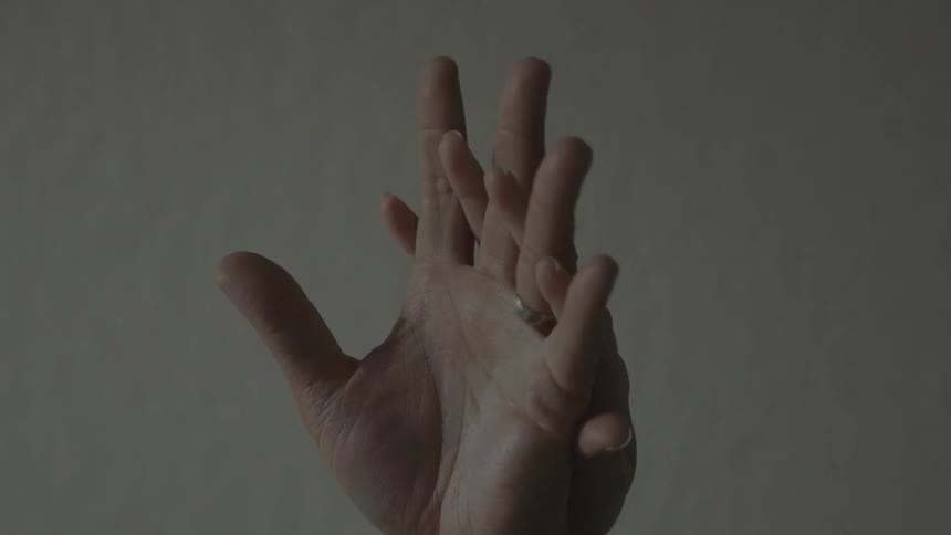 A man's hand and a woman's hand entwining each other and caressing each other