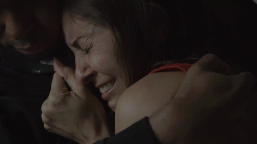 A man holding a woman as she cries