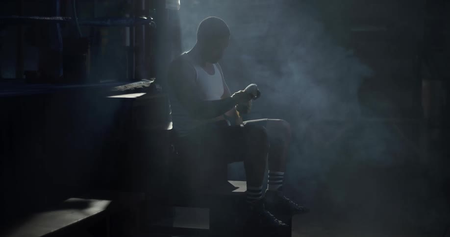 A man wraps his hand and wrist in athletic tape