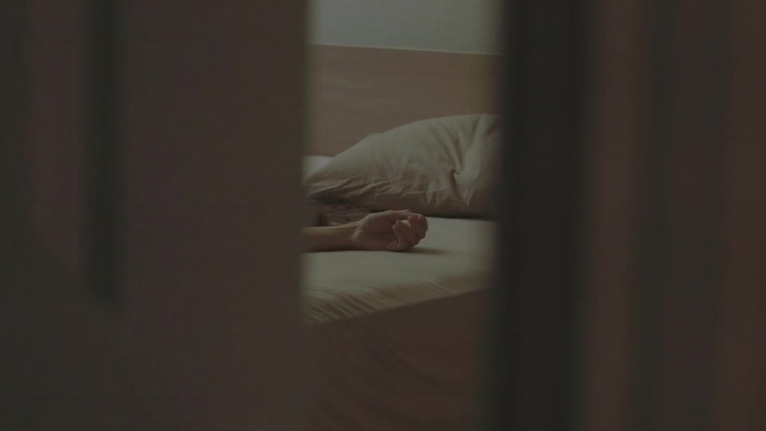 A door slowly opens showing a person in bed